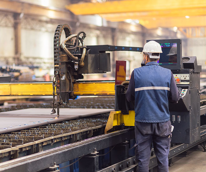 steel worker using plasma cutter machine