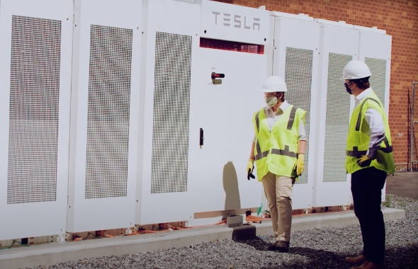 engineers in front of Enel X battery energy storage system at UMass Boston