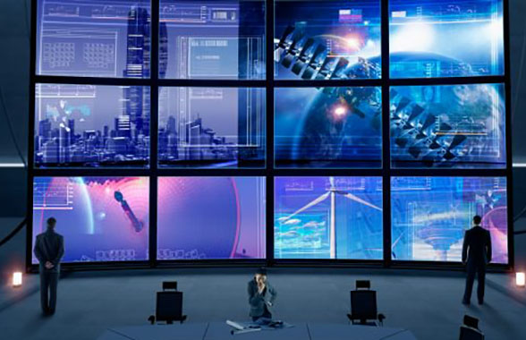 business people watching large grid of monitors