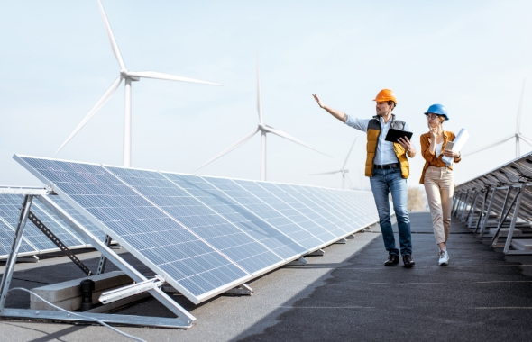 engineers walking and discussing on rooftop with solar panels