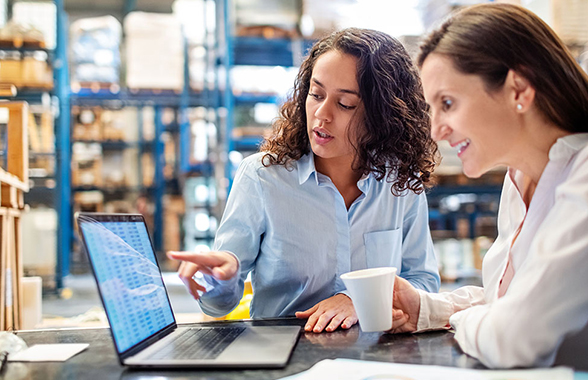 Two women review information together on a computer