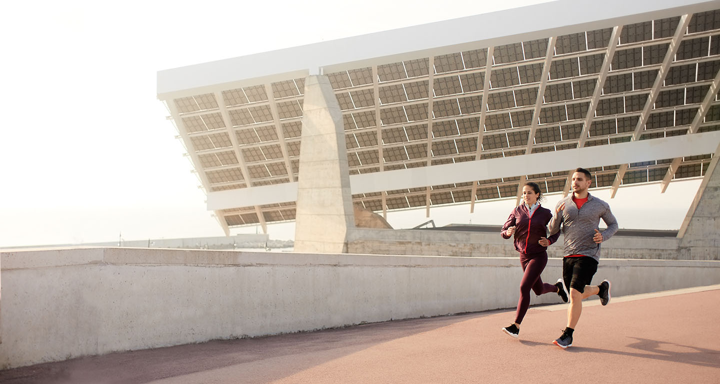 couple running with solar panels in background