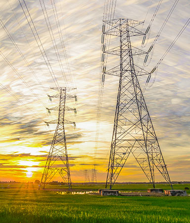 electricity pylons with sun low in sky